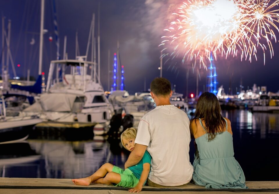 Happy,Family,With,Child,,Watching,Fireworks,On,A,Port,,Sitting